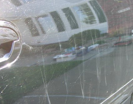 Close-up of scratches and swirl marks on vehicle paint